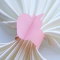 Detailed view of a pink apple-shaped paper napkin ring with a pearlescent finish - 17.5cm / Pink