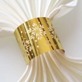 Macro shot of gold laser-cut snowflake napkin ring with elegant white satin cloth detail - Mirror Gold