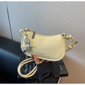 Detail of pale yellow crescent bag featuring wrinkled texture and silver balloon dog charm - Yellow (With Pendant)