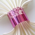 Detail of pink laser-cut lace napkin ring with mirror finish on white satin cloth - Nail Powder