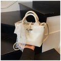Detail view of cream patent leather handbag with lace scarf and pearl chain charm - Beige With Charm