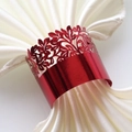 Macro shot of red laser-cut floral metal napkin ring with shiny finish on white satin - Mirror Red