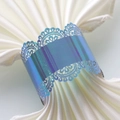 Close-up of laser-cut lace napkin ring in iridescent purple for wedding table decor - Rainbow Blue