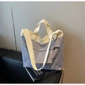 Détail du sac fourre-tout en toile à rayures bleues avec anses blanc cassé sur canapé - Rayé