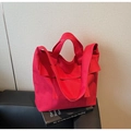 Vista dettagliata di una borsa tote in tela rossa con tasche su una superficie di pelle - Taglia unica / Borgogna
