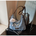 Detail of blue denim tote bag with floral pattern, pearl chain, and cloud charm - Blue
