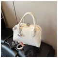 Detalle de textura de cuero lichi blanco y colgante de delfín en el bolso bowling - Blanco Roto