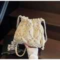 Gros plan du sac seau au crochet beige avec motif ajouré et bandoulières tressées - Blanc