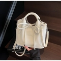 Détail d'un sac à main en similicuir crème avec nœud décoratif et finitions argentées - Blanc Cassé