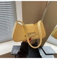 Détail d'un sac sous le bras en cuir embossé jaune clair avec décoration de nœud - Jaune