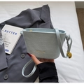 Detailaufnahme der hellblauen Krokodil-Texturtasche mit goldenem Logo und Anhänger - Blau