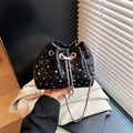 Fashionable black quilted bucket bag with silver studs and chain strap held by a model - Black No Handle