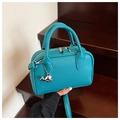 Détail du sac bowling bleu sarcelle en cuir grainé avec breloque baleine argentée - Bleu