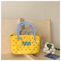 Detail of yellow EVA tote with blue handles, cartoon charms and linen drawstring liner - Yellow