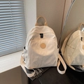 Cream white nylon backpack with brown logo patch and side pockets on books - White