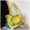 Detailed macro view of yellow lychee pattern tote bag with leather bow charm and long straps - Fruit Green