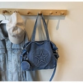 Close-up of a blue denim tote bag with embossed star detail and mini pouch on a hook - Light Blue