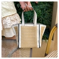 Close-up of beach straw tote bag featuring white faux leather contrast and weave texture - White
