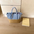 Detail of blue striped canvas and woven straw base on the vacation tote bag - Blue