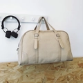 Large beige canvas and leather travel duffel bag with handles hanging on a hook - Khaki