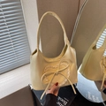 Creamy yellow tote bag featuring a lace heart and leather bow accent for spring - Yellow