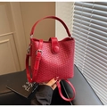 Detail of red woven bucket bag with fine leather texture and metal buckle closure - Burgundy