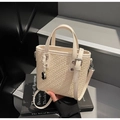 Close-up of cream woven mini tote bag with leather straps and metallic charm detail - Off-white