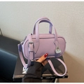 Close-up of purple pebble grain leather mini handbag with a small silver lock charm - Purple
