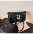 Detalle de un bolso de hombro de cuero negro brillante con hebilla ovalada de metal dorado - Negro