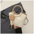 Dettaglio borsa a secchiello crema con manico kaki e ciondolo a forma di orsetto - Bianco Sporco