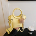 Light yellow bucket bag in glossy finish with round handle and teddy bear charm - Yellow