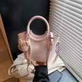 Pink glossy bucket bag with round handle, plush bear charm and striped scarf detail - Pink
