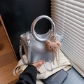 Silver metallic bucket bag with ring handle, crossbody strap, and bear charm accessory - Silver