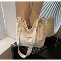 Detail of white canvas tote bag featuring distressed pocket edges and adjustable strap - Off White