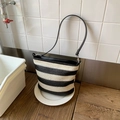 Detailed texture of black and white striped woven bucket bag with faux leather strap - Black and White