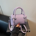 Purple lychee pattern leather pillow bag with top handles and a silver padlock detail - Purple
