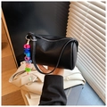 Détail du sac cylindre en cuir noir à motif litchi avec breloque lettre colorée - Noir avec pendentif