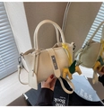 Detailansicht der cremeweißen Krokodilleder-Handtasche mit silbernem Schloss und Anhänger - Weiß mit Anhänger