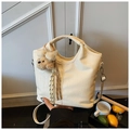 Detail of cream crocodile embossed handbag with metal hardware and plush animal charm - White with Pendant