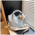 Light blue faux crocodile bucket bag with cute bear charm on a trench coat background - Blue with Charm