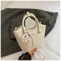 Détail d'un sac seau en cuir blanc crème avec un ruban rose et une bandoulière amovible - Avec Pendentif / Blanc