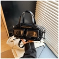 Detail of black patent leather crossbody bag with bow accents and dual front pockets - Black