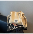 Close-up of cream drawstring bucket bag with silver chain and mikaxiqi textile label - Yellow