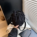 Minimalist black drawstring bucket bag made of nylon with mesh side pockets and strap - Black