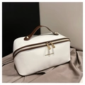 Detail of white leather makeup bag with brown handles and gold rivets, 45-degree view - Brown