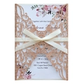 Détail d'invitation rose doré pailleté découpé au laser avec fleurs et nœud en satin - Or Champagne Pailleté