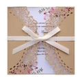 Detail of laser cut wedding invitation with floral inner card and cream ribbon bow - Beige Gold