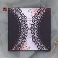 Detalle de invitación de boda calada con corte láser e inserto floral sobre malla - Negro