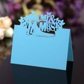 Macro shot of light blue laser-cut wedding place card with Mr & Mrs silhouette design - Tiffany Blue