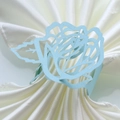 Détail macro du rond de serviette en papier rose bleu clair découpé au laser sur satin - Bleu Pâle Perlé